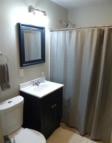 a bathroom with a sink vanity mirror and toilet