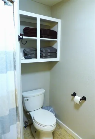 a white toilet sitting next to a window