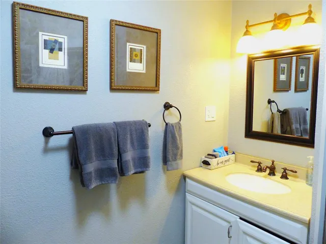 a bathroom with a granite countertop sink and a mirror