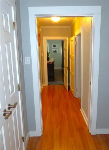a view of a hallway with wooden floor and a living room