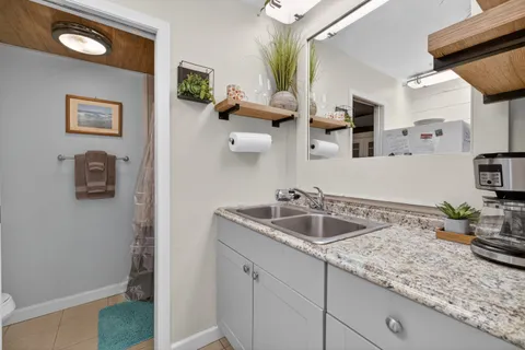 a bathroom with a granite countertop sink and a mirror