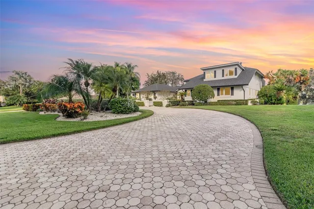 a view of a white house with a big yard and a large trees
