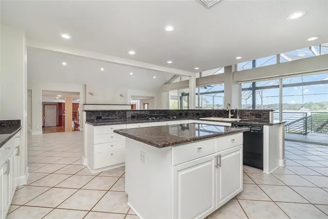 a large kitchen with stainless steel appliances granite countertop a sink and cabinets with wooden floor