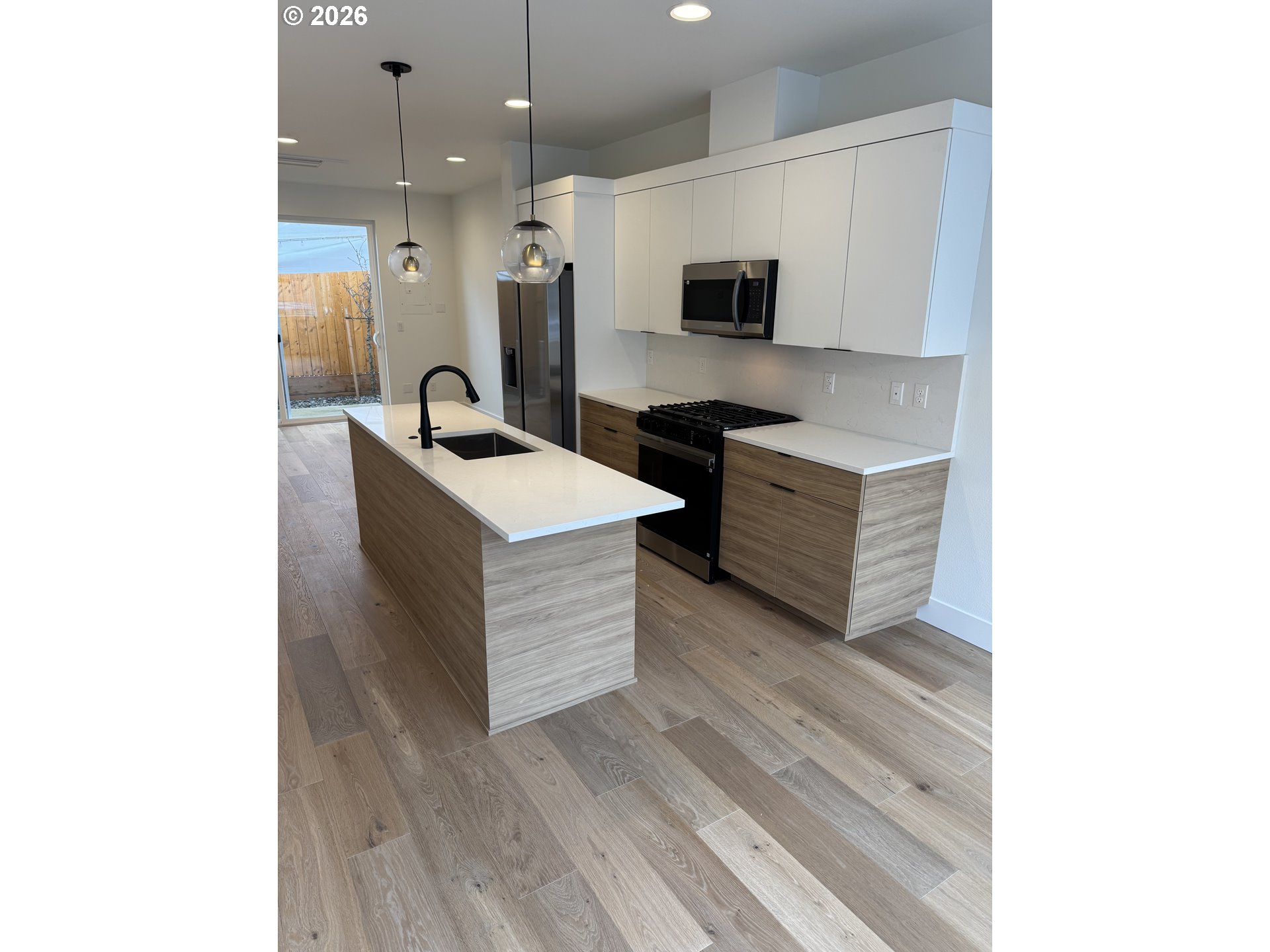 2383 Southeast 43rd Avenue Portland, OR 97206 - Photo 6 of 24 a kitchen with stainless steel appliances a stove top oven with wooden floor