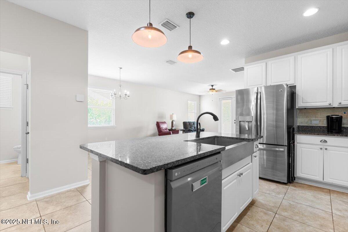 1011 Wetland Ridge Circle Middleburg, FL 32068 - Photo 14 of 73 a kitchen with stainless steel appliances granite countertop a sink refrigerator and cabinets