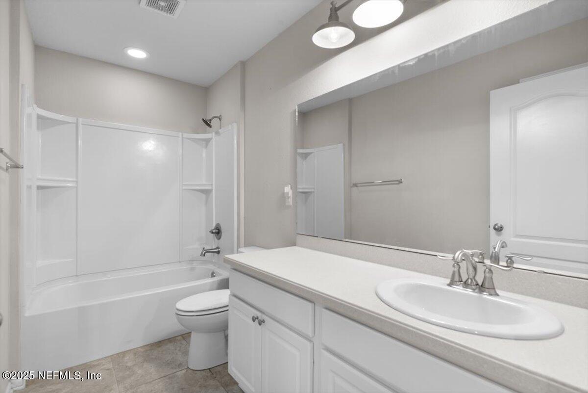 1011 Wetland Ridge Circle Middleburg, FL 32068 - Photo 42 of 73 a bathroom with a granite countertop sink a toilet and shower