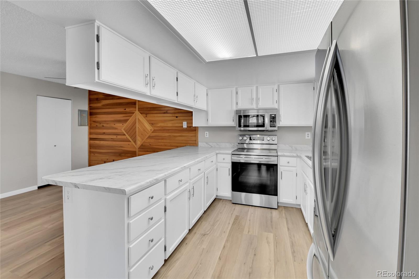 9501 West 89th Circle Broomfield, CO 80021 - Photo 6 of 33 a kitchen with white cabinets and stainless steel appliances