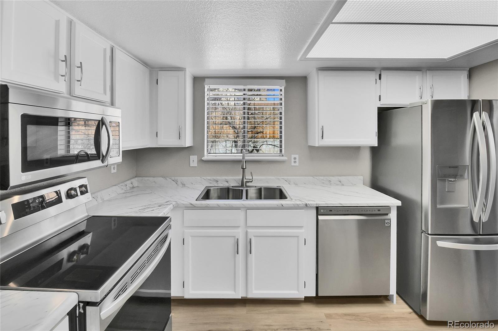 9501 West 89th Circle Broomfield, CO 80021 - Photo 8 of 33 a kitchen with white cabinets stainless steel appliances and sink