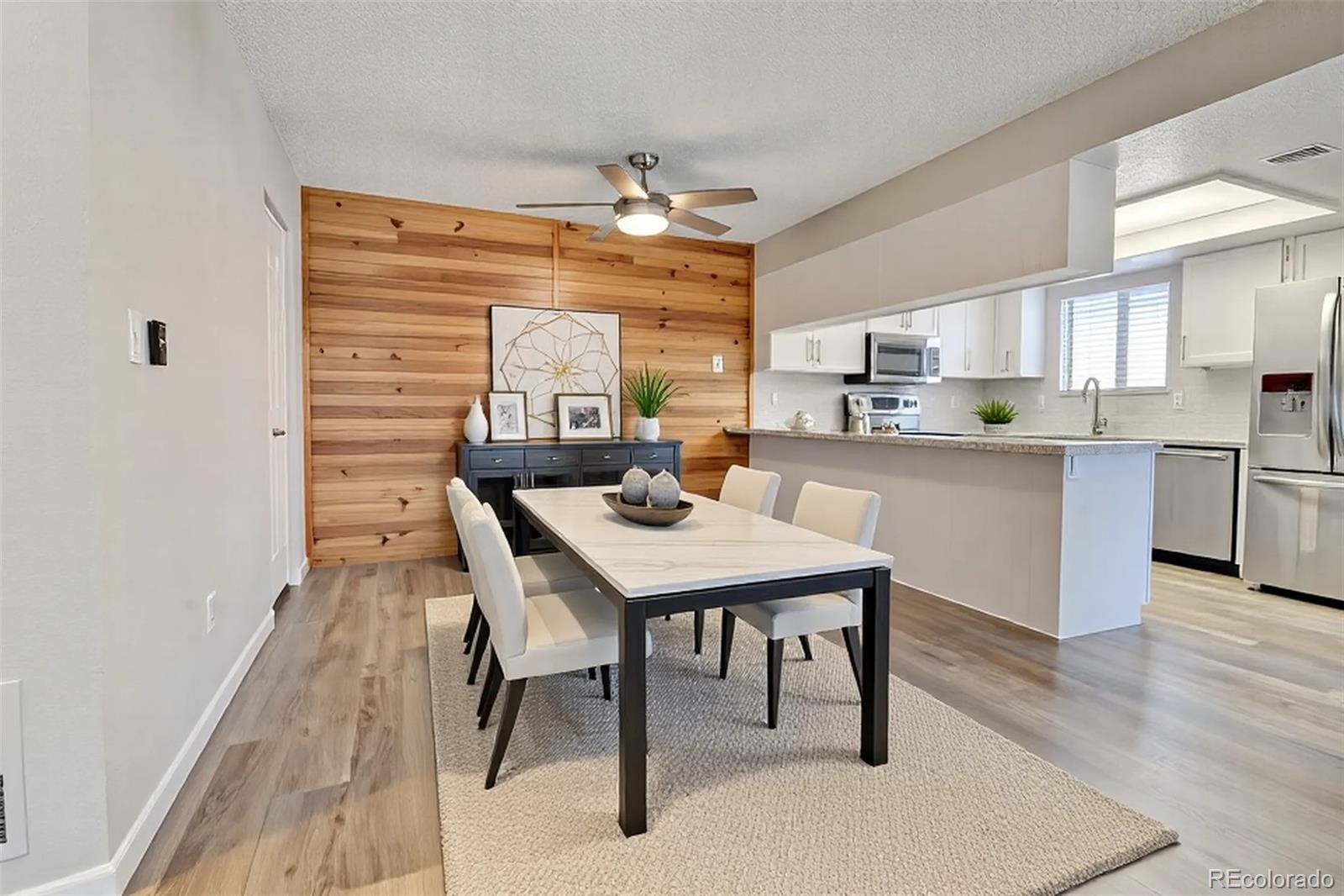 9501 West 89th Circle Broomfield, CO 80021 - Photo 10 of 33 a kitchen with stainless steel appliances kitchen island granite countertop a table chairs sink and cabinets