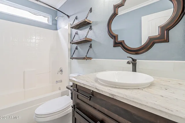 a bathroom with a sink a toilet and a mirror