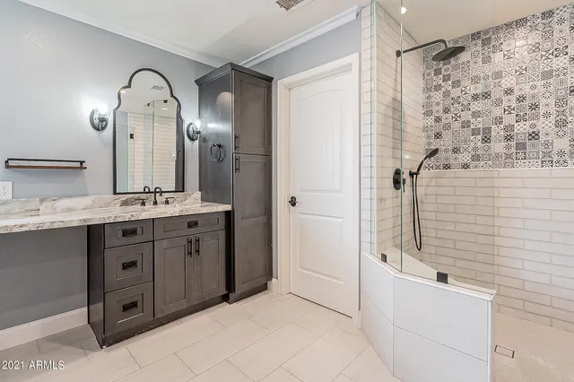 a bathroom with a double vanity sink mirror and shower