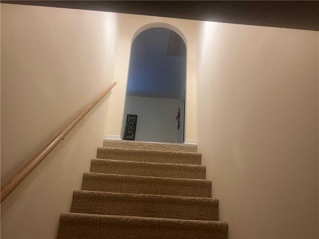 521 Calhoun Shores Parkway Calhoun Falls, SC 29628 - Photo 12 of 39 This interior staircase offers seamless access between levels, featuring carpeted steps and an arched doorway.
