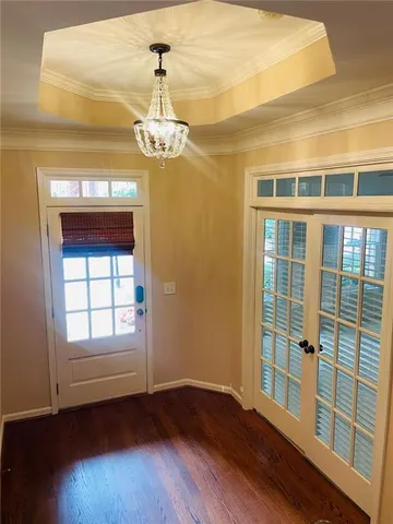 an empty room with windows and chandelier