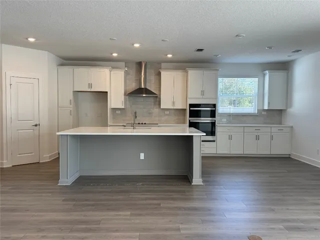 a large kitchen with stainless steel appliances granite countertop a stove a sink and a refrigerator