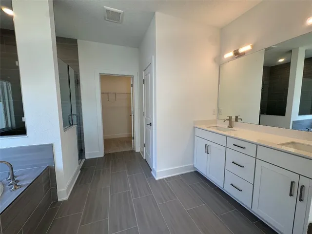 a spacious bathroom with 2 sink and a mirror