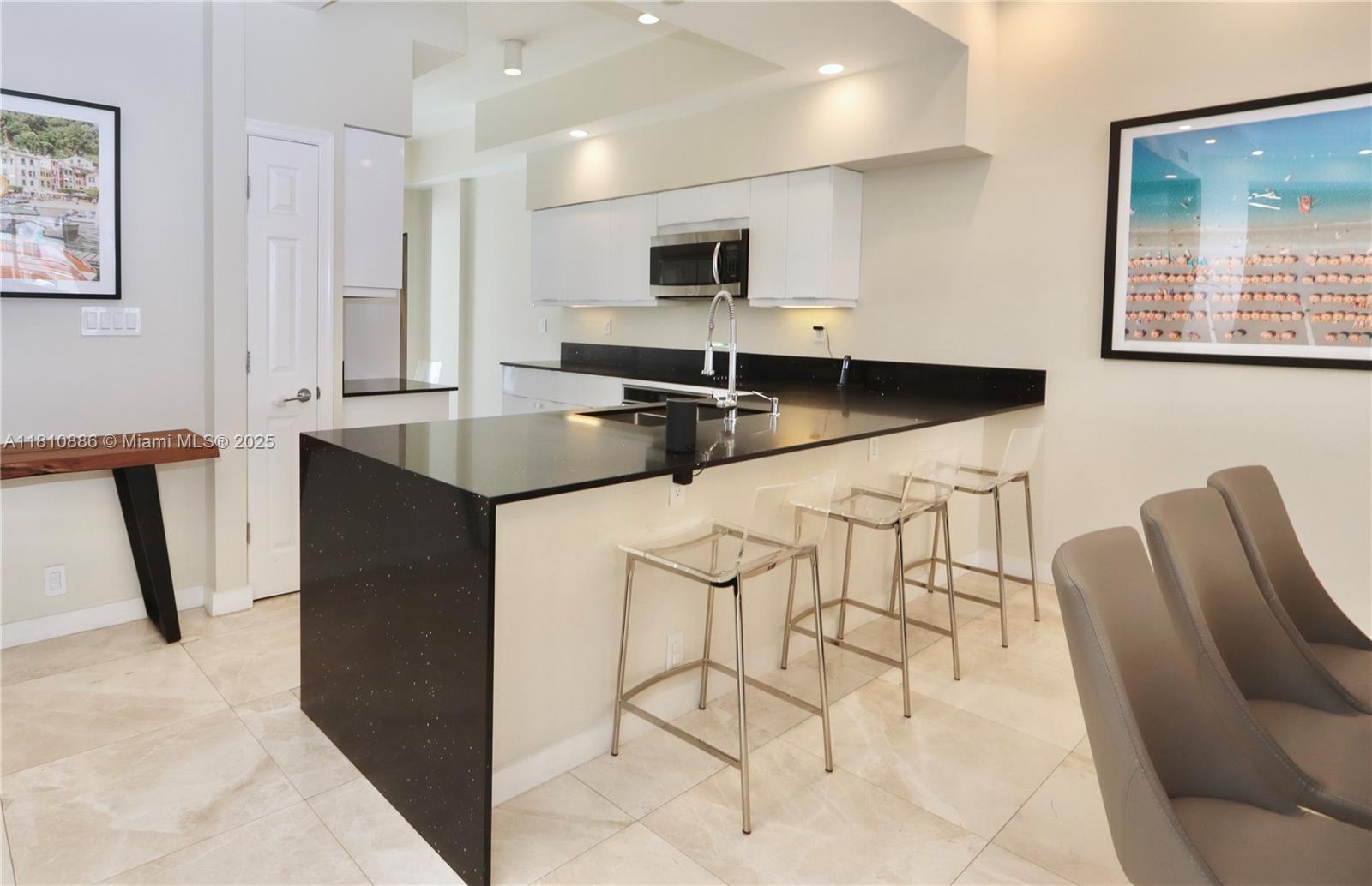 3900 Island Boulevard, Unit PH2 Aventura, FL 33160 - Photo 9 of 39 a kitchen with stainless steel appliances kitchen island granite countertop a stove a sink a refrigerator and a microwave