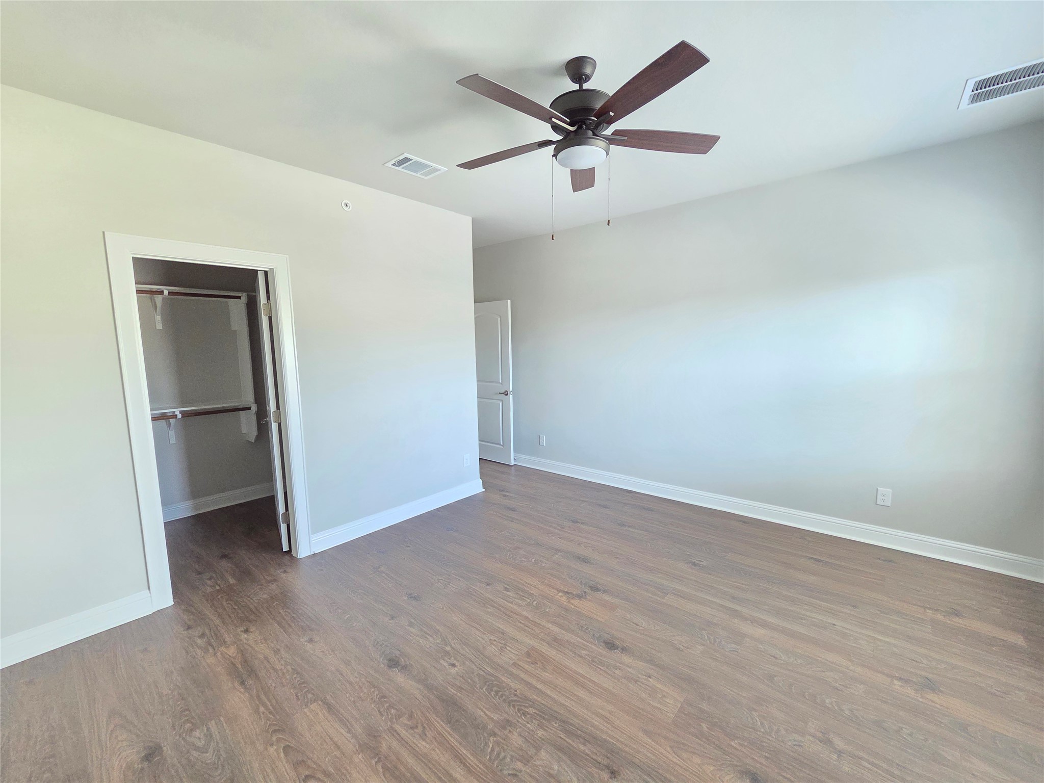600 C-Bar Ranch Trail, Unit 121 Cedar Park, TX 78613 - Photo 24 of 32 A spacious room features rich wood flooring and a modern ceiling fan for comfort.