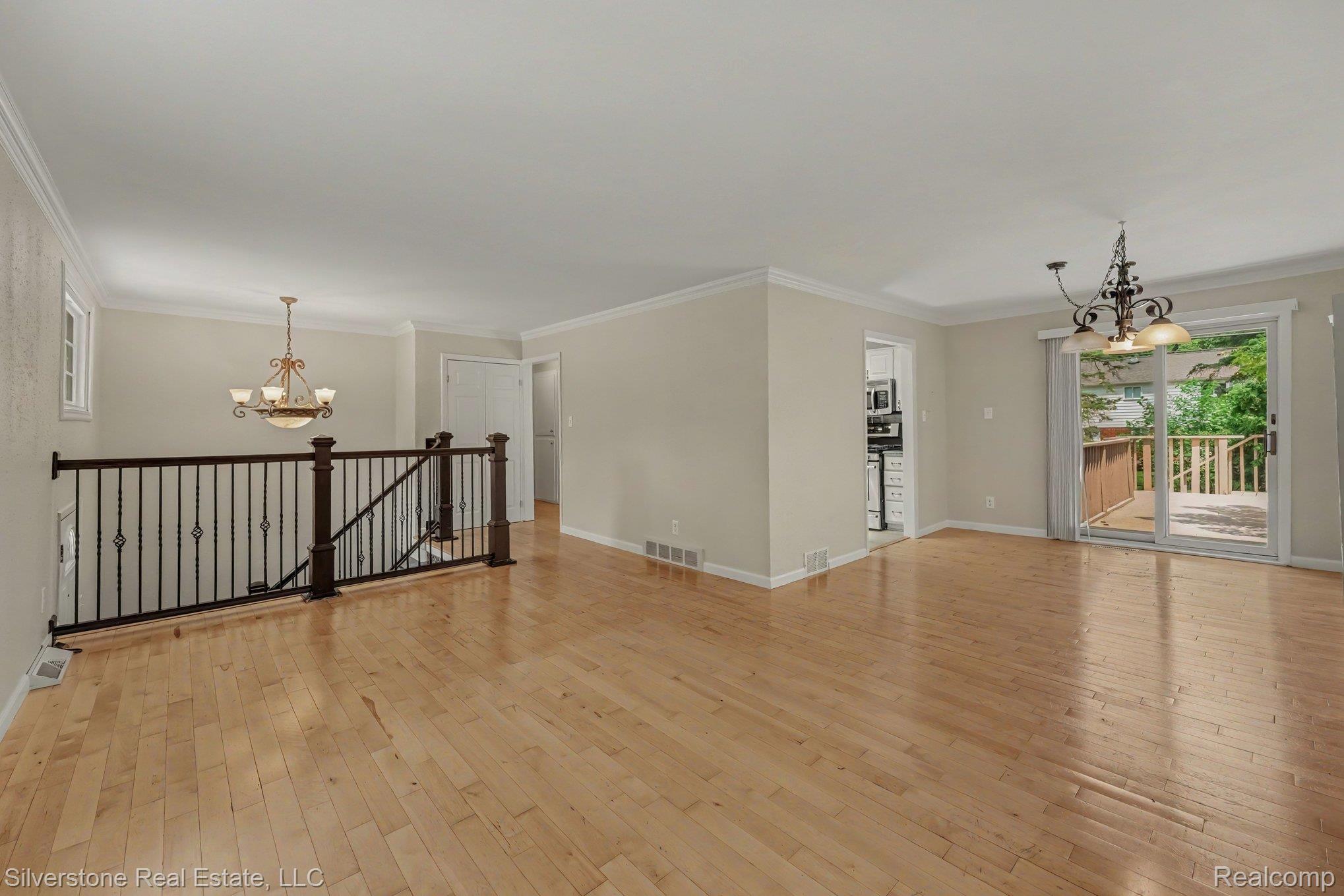 547 Reed Street Northville, MI 48167 - Photo 7 of 38 Open-concept living space featuring wood-finish flooring, white walls, and crown molding