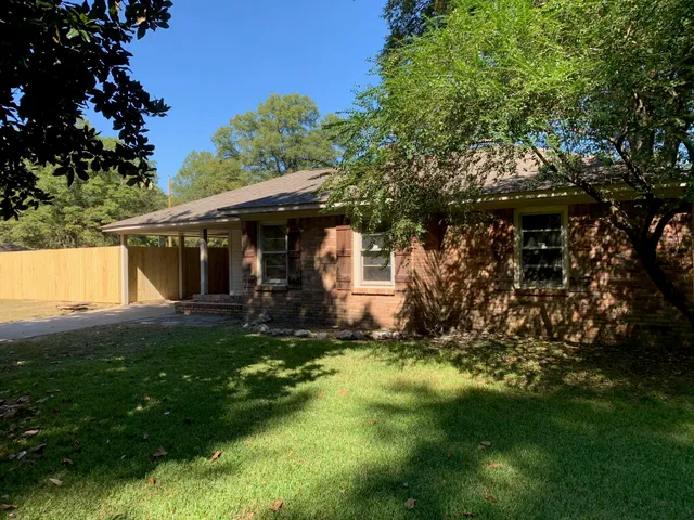 a view of a house with a yard and sitting area