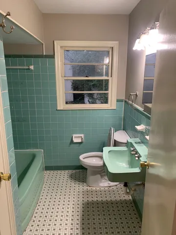 a bathroom with a toilet a sink and mirror
