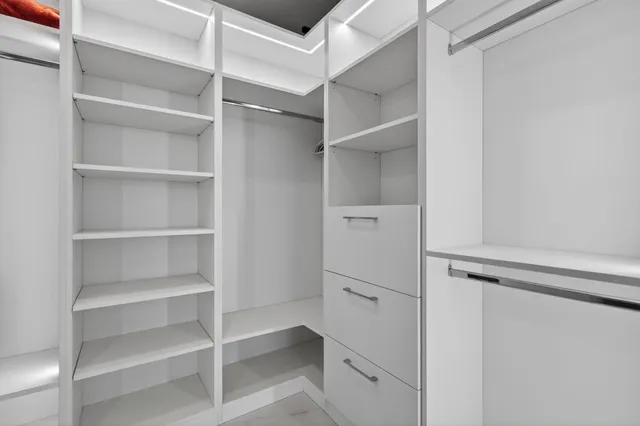a view of walk in closet with empty racks