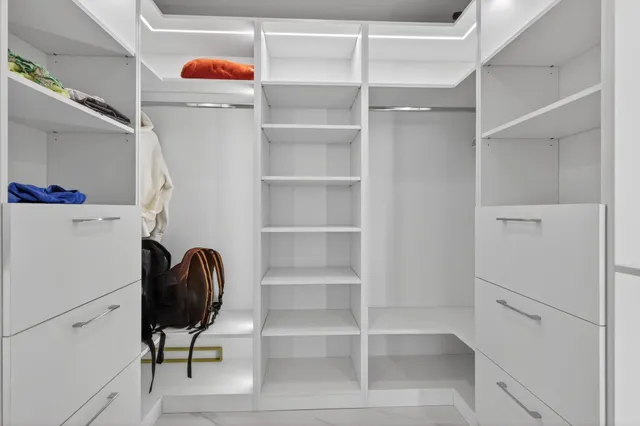 a view of walk in closet with empty racks