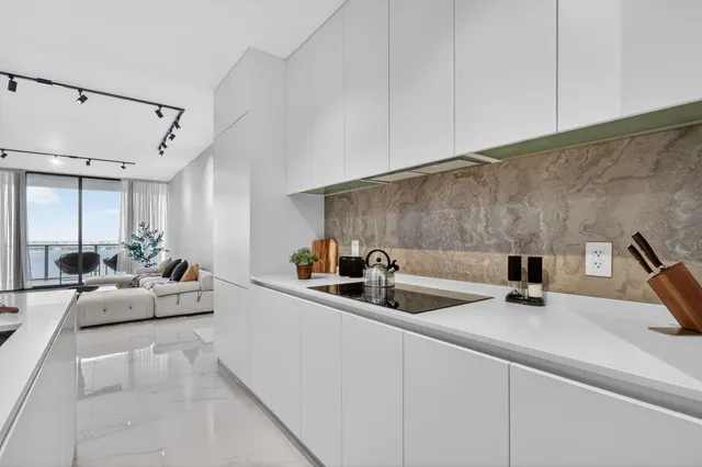 a kitchen with a sink a stove and white cabinets