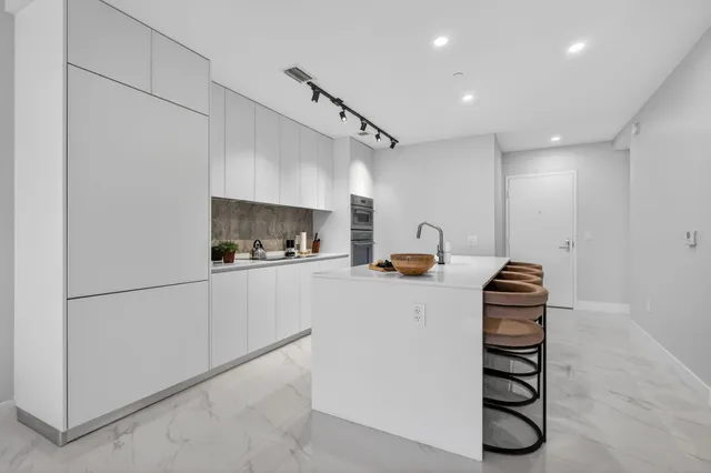 a kitchen with granite countertop white cabinets and white appliances
