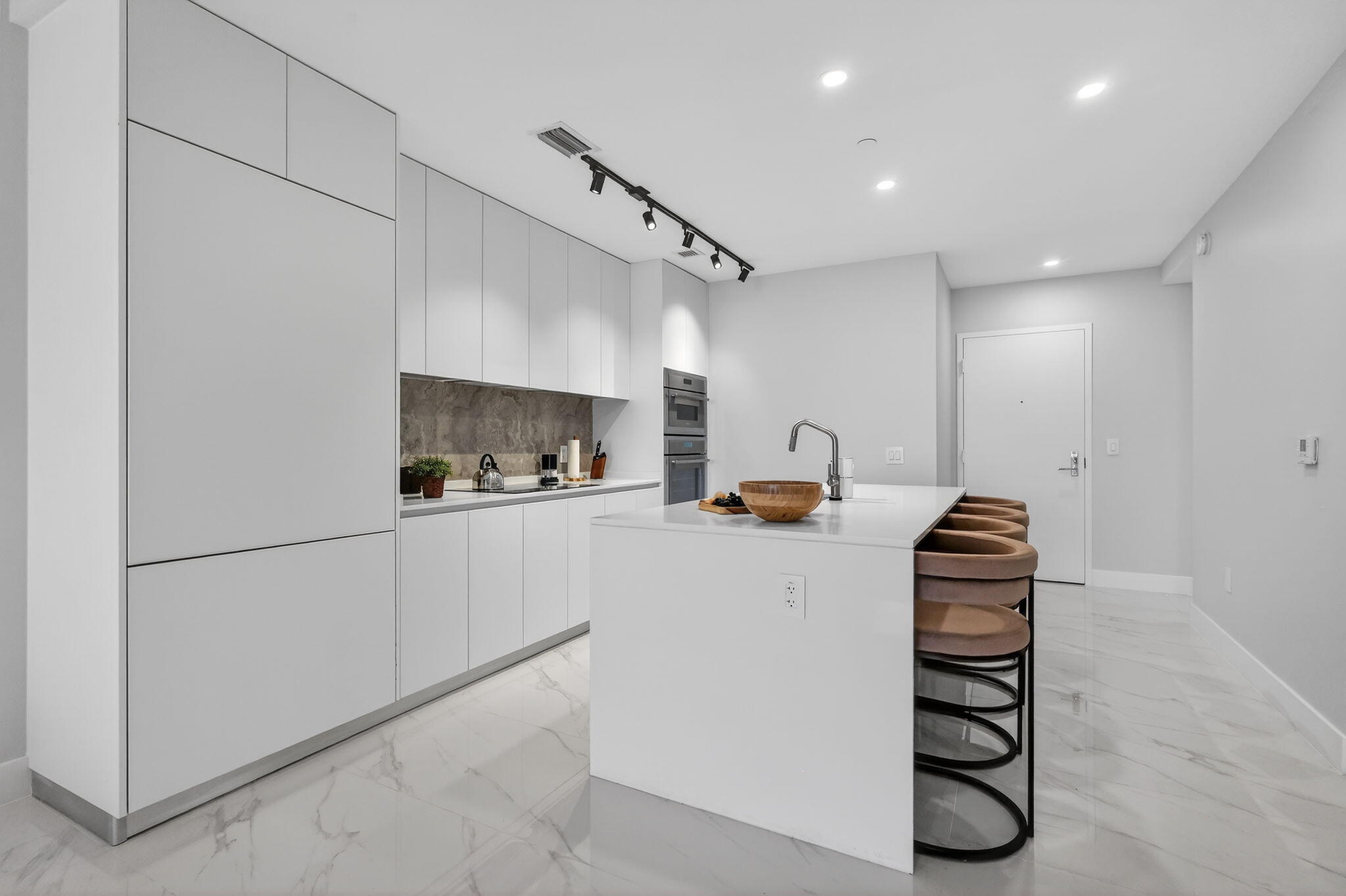 700 Northeast 23rd Street, Unit 3206 Miami, FL 33137 - Photo 6 of 37 a kitchen with granite countertop white cabinets and white appliances