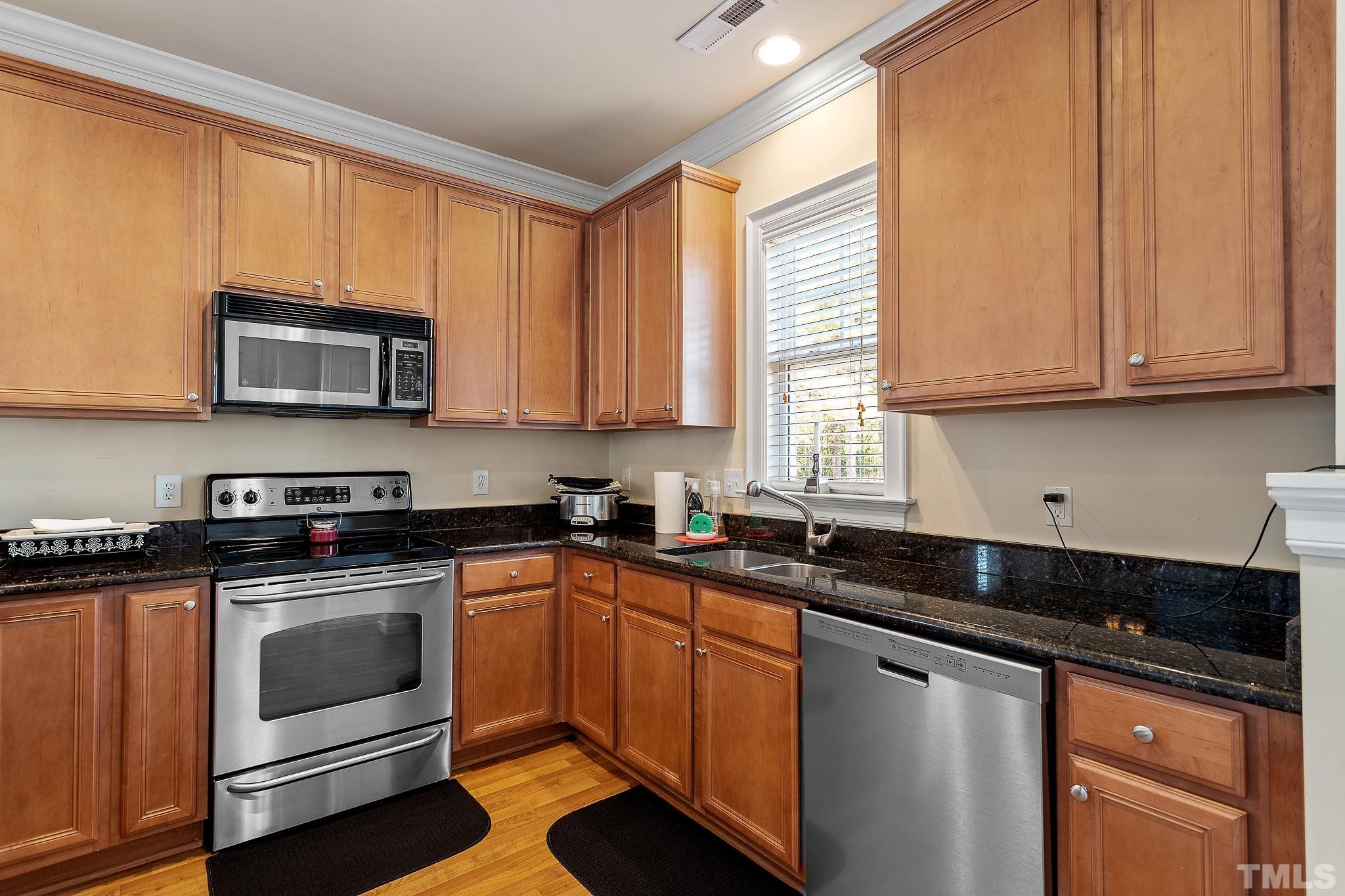 7708 Alexander Promenade Place Raleigh, NC 27617 - Photo 11 of 27 a kitchen with granite countertop cabinets stainless steel appliances a sink and window