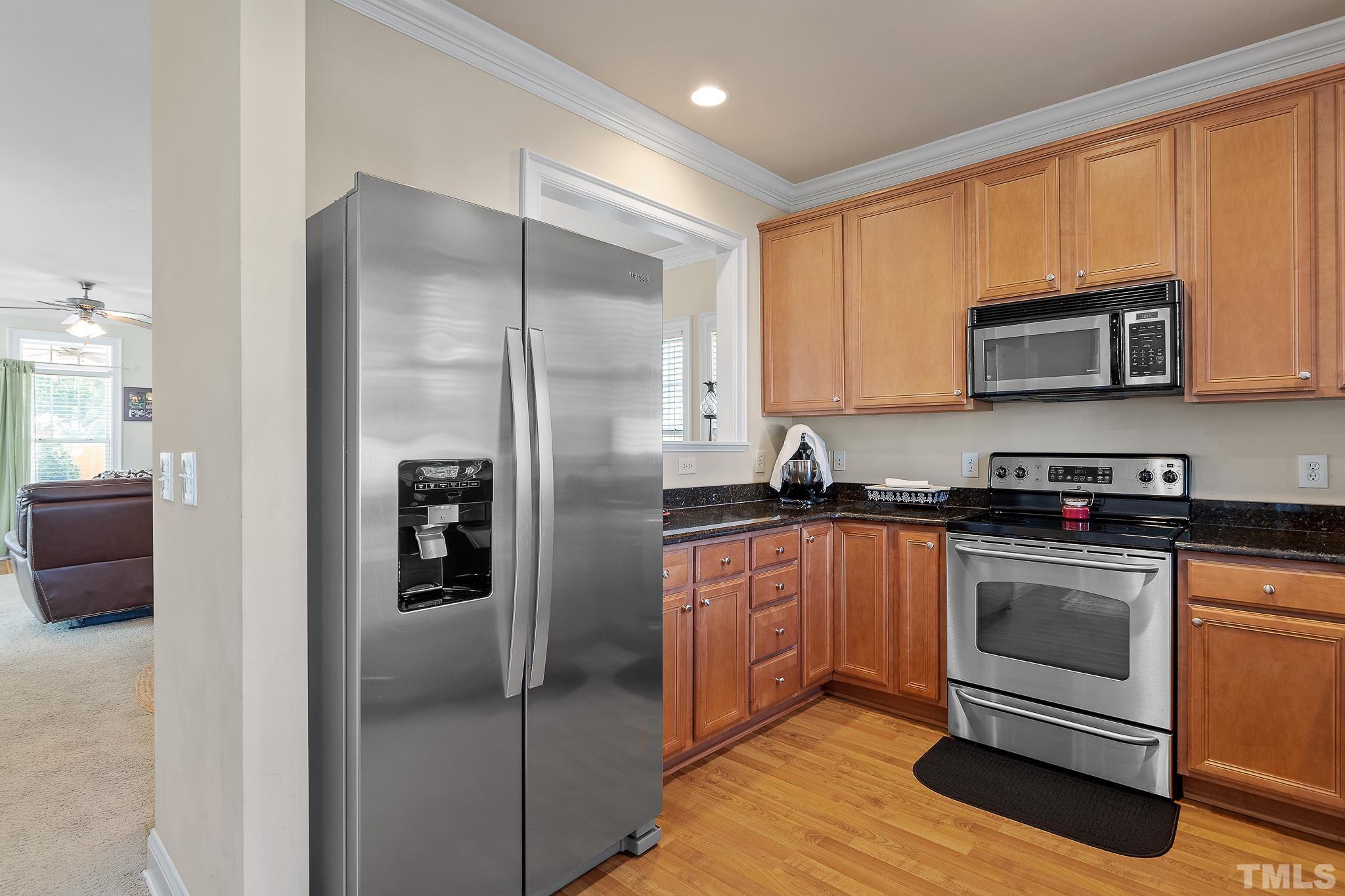7708 Alexander Promenade Place Raleigh, NC 27617 - Photo 12 of 27 a kitchen with stainless steel appliances granite countertop a refrigerator stove and microwave