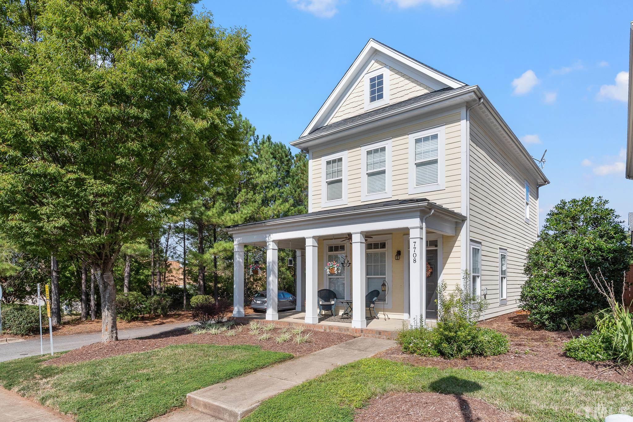7708 Alexander Promenade Place Raleigh, NC 27617 - Photo 2 of 27 a front view of a house with a yard table and chairs