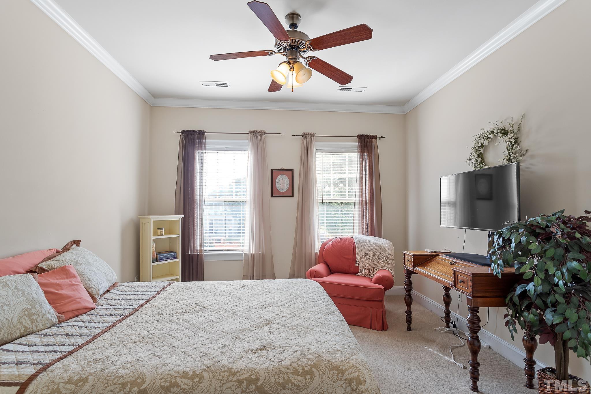 7708 Alexander Promenade Place Raleigh, NC 27617 - Photo 23 of 27 a bedroom with a bed and a chandelier