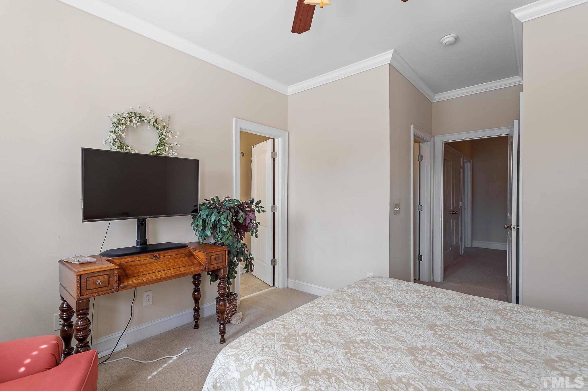7708 Alexander Promenade Place Raleigh, NC 27617 - Photo 24 of 27 a bedroom with a bed and flat screen tv