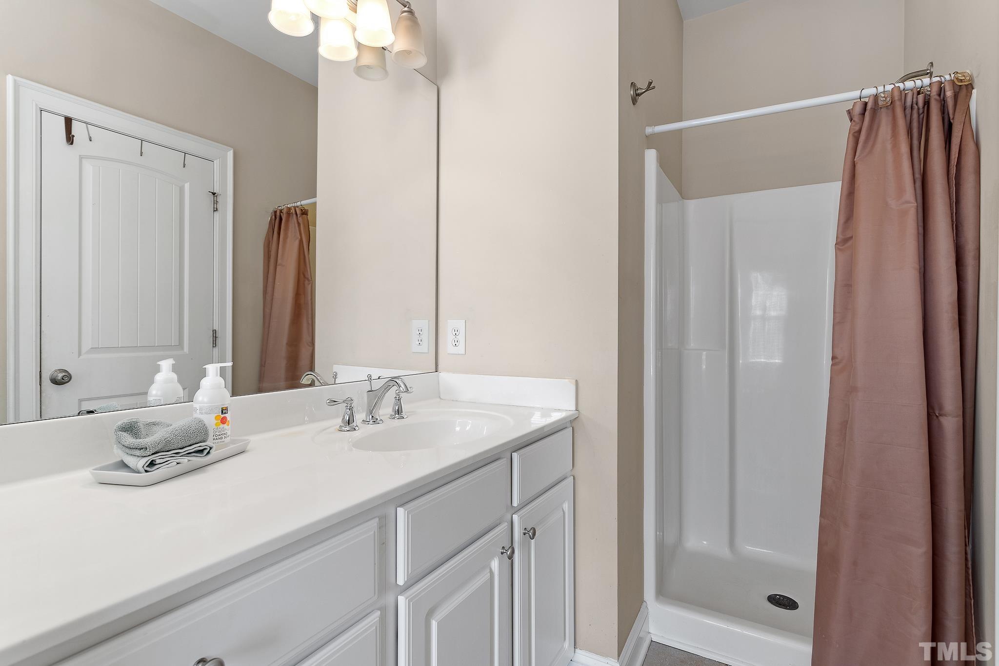 7708 Alexander Promenade Place Raleigh, NC 27617 - Photo 26 of 27 a bathroom with a double vanity sink and a mirror