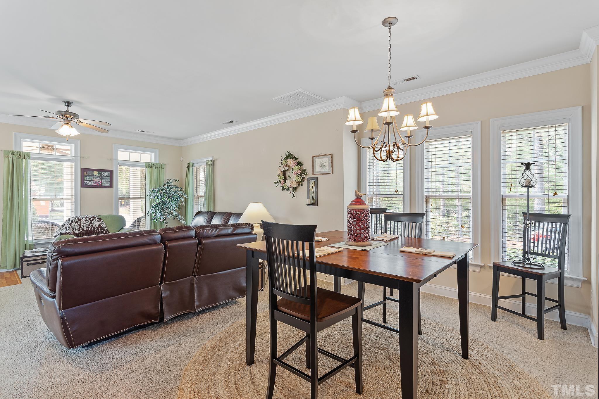 7708 Alexander Promenade Place Raleigh, NC 27617 - Photo 8 of 27 a view of a dining room with furniture and chandelier