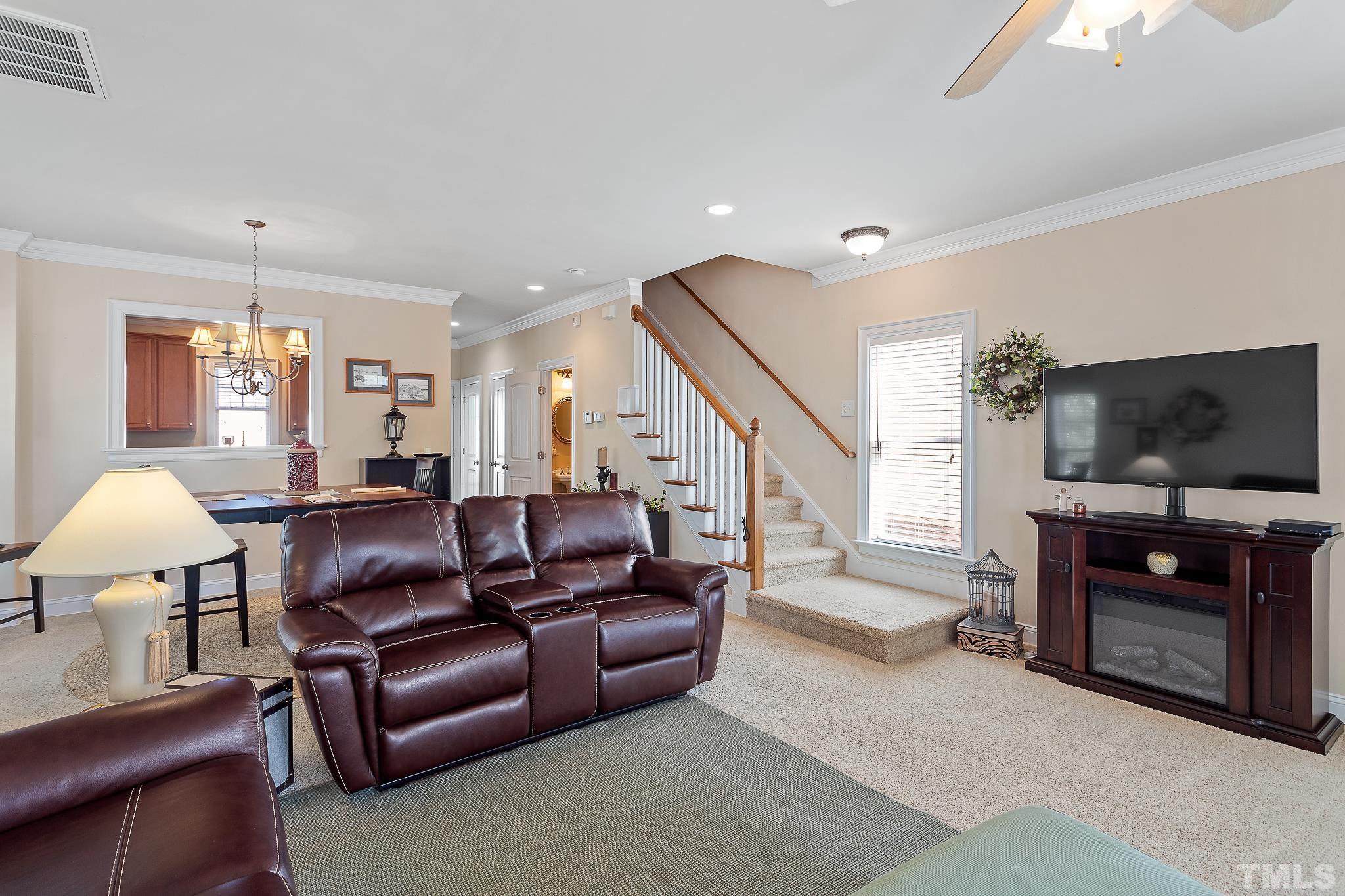 7708 Alexander Promenade Place Raleigh, NC 27617 - Photo 10 of 27 a living room with furniture and a flat screen tv