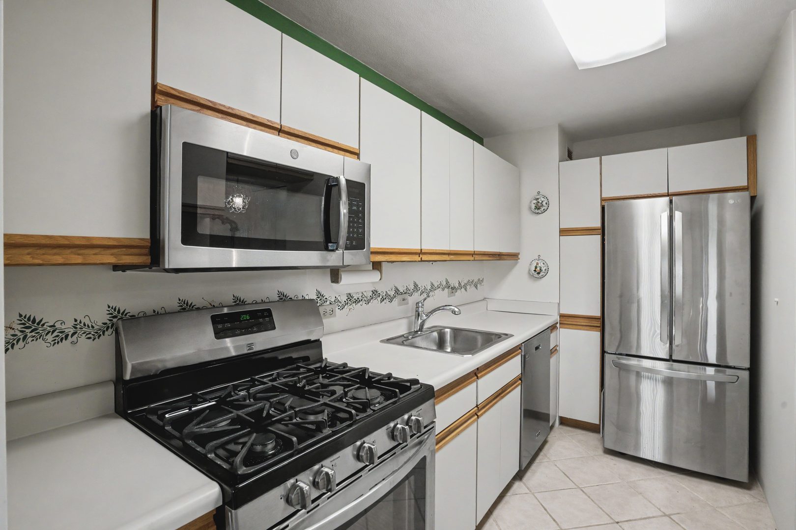 1800 7th Street, Unit 5D East Moline, IL 61244 - Photo 10 of 24 a kitchen with stainless steel appliances a refrigerator a sink and white cabinets