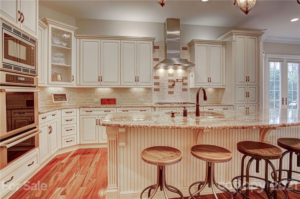 2105 South Wendover Road Charlotte, NC 28211 - Photo 11 of 46 a kitchen with granite countertop a sink chairs and cabinets