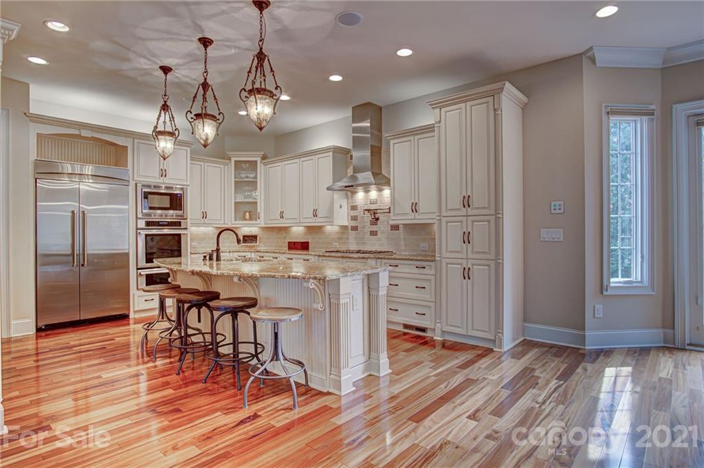 2105 South Wendover Road Charlotte, NC 28211 - Photo 12 of 46 a kitchen with stainless steel appliances kitchen island granite countertop a table chairs and a refrigerator