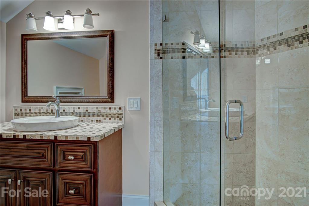 2105 South Wendover Road Charlotte, NC 28211 - Photo 37 of 46 a bathroom with a granite countertop sink a shower and a mirror