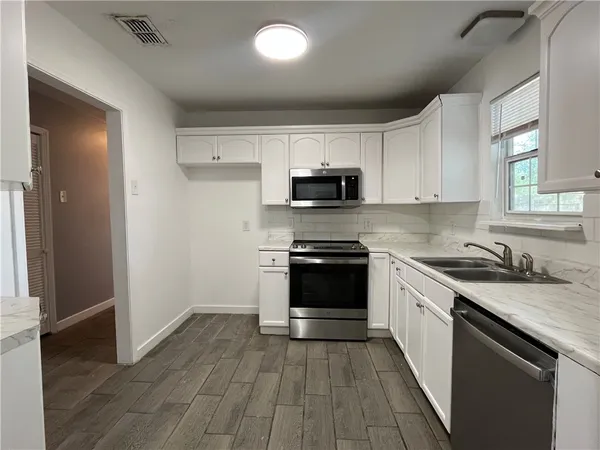 a kitchen with a sink stove and cabinets