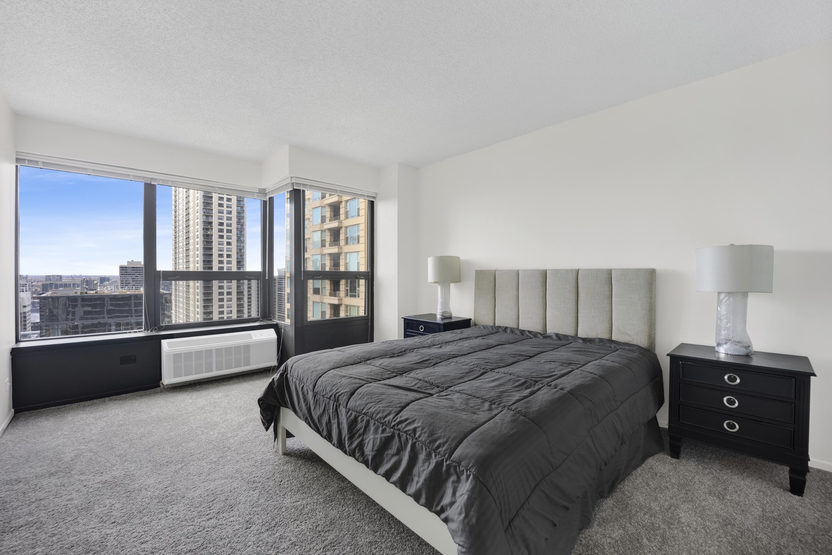 30 East Huron Street, Unit 3204 Chicago, IL 60611 - Photo 12 of 17 a spacious bedroom with a bed and a large window