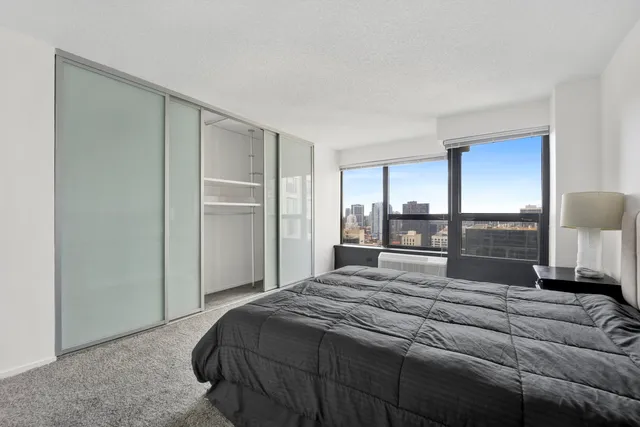 a bedroom with a large bed and a lamp