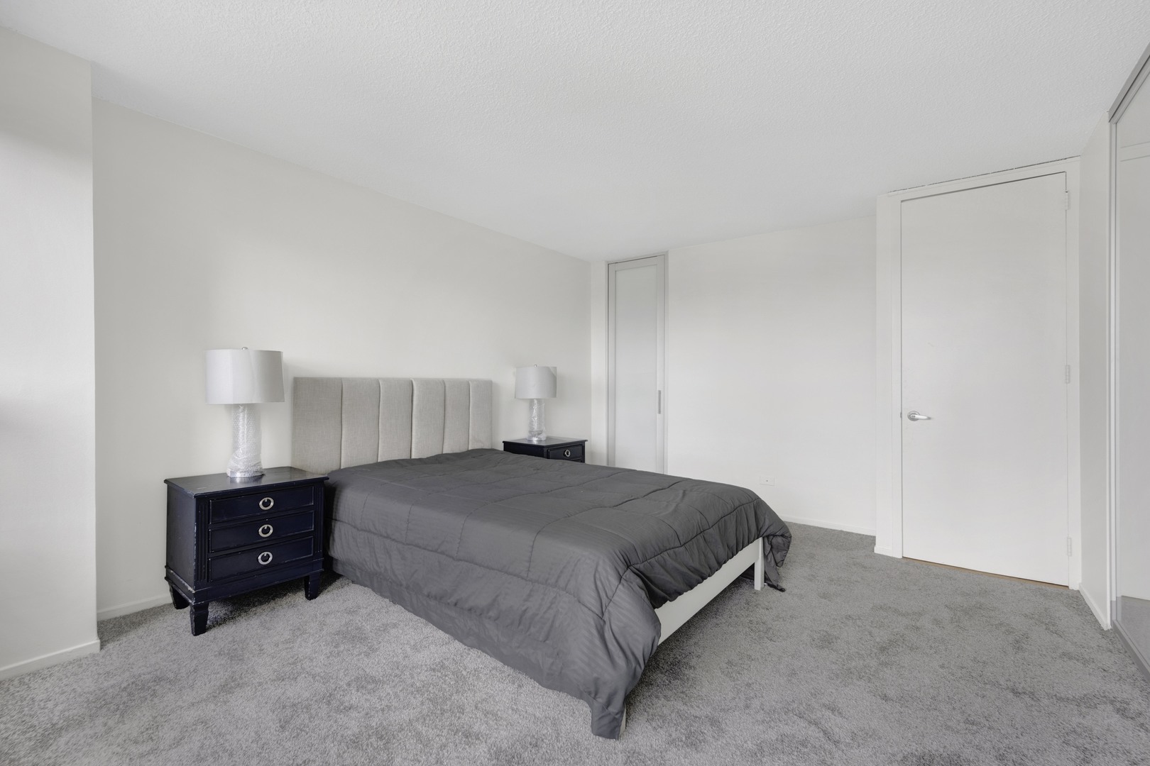 30 East Huron Street, Unit 3204 Chicago, IL 60611 - Photo 14 of 17 a bedroom with a bed and lamp