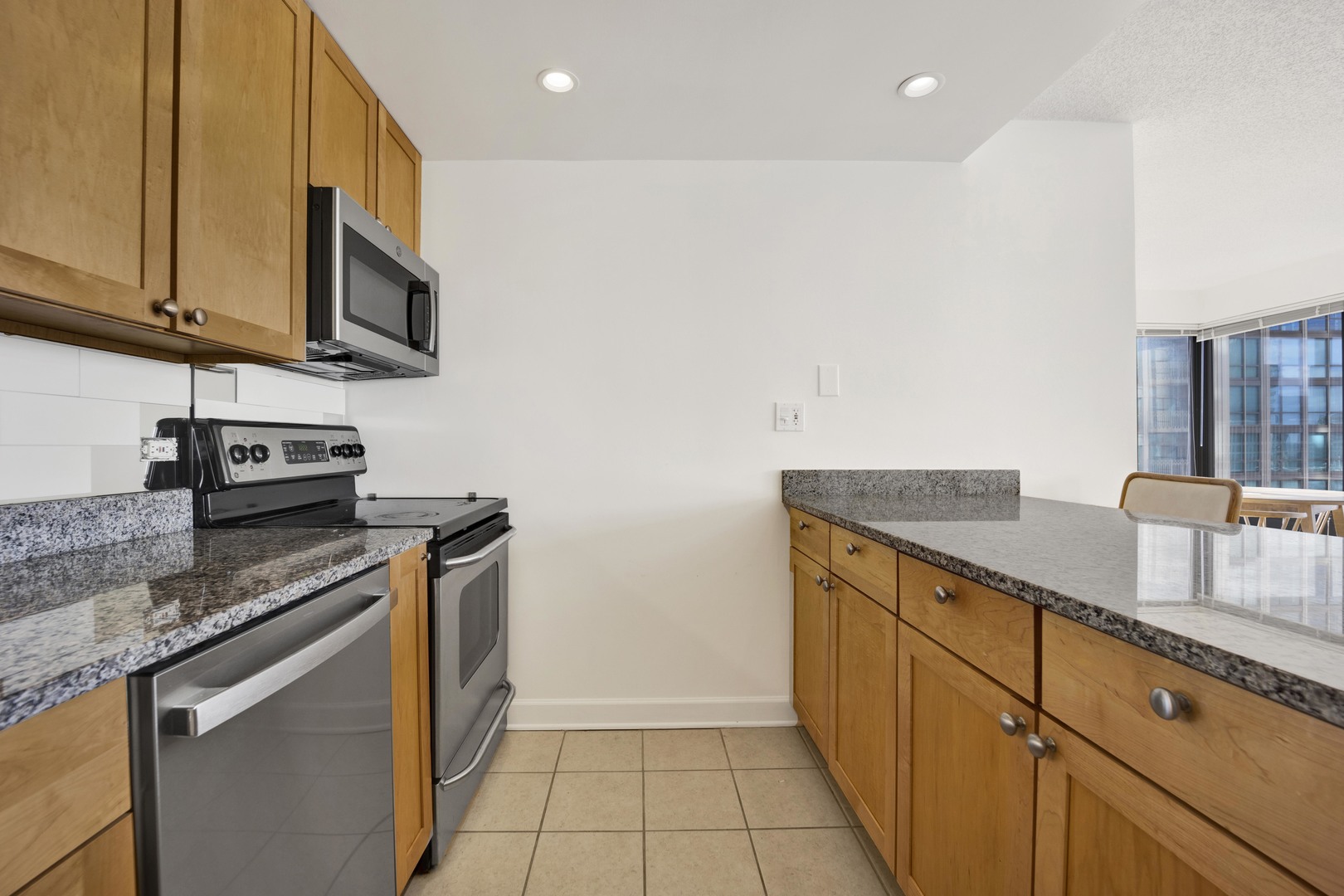 30 East Huron Street, Unit 3204 Chicago, IL 60611 - Photo 5 of 17 a kitchen with stainless steel appliances granite countertop a sink and a stove