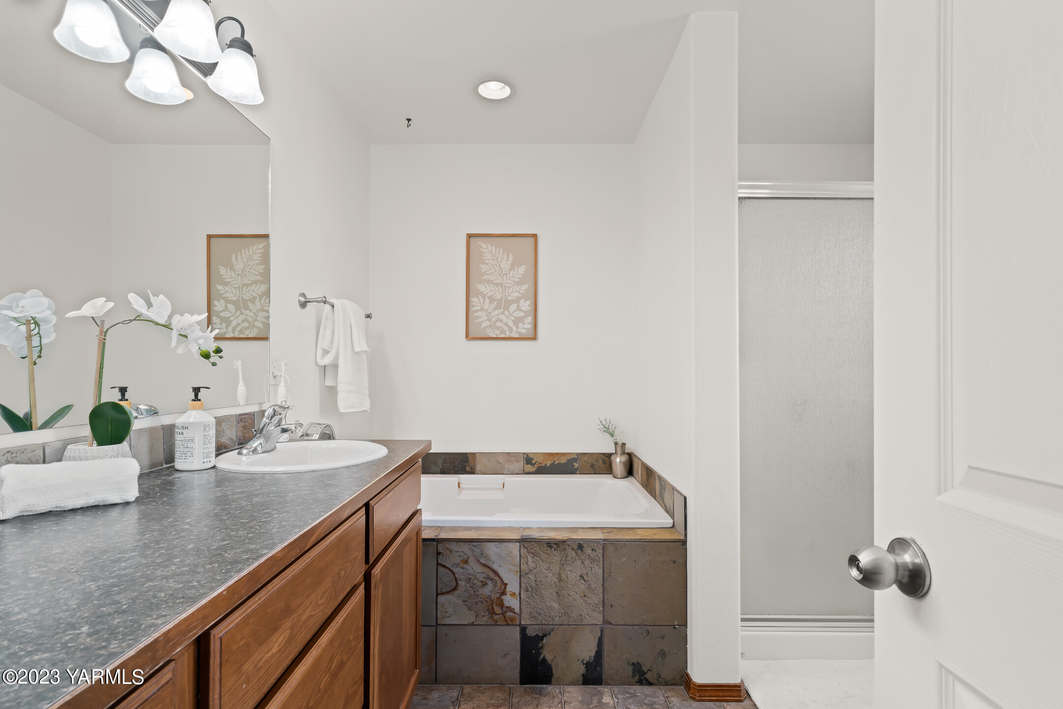 4702 Goat Rocks Court Yakima, WA 98901 - Photo 23 of 36 a bathroom with a granite countertop sink a mirror and vanity