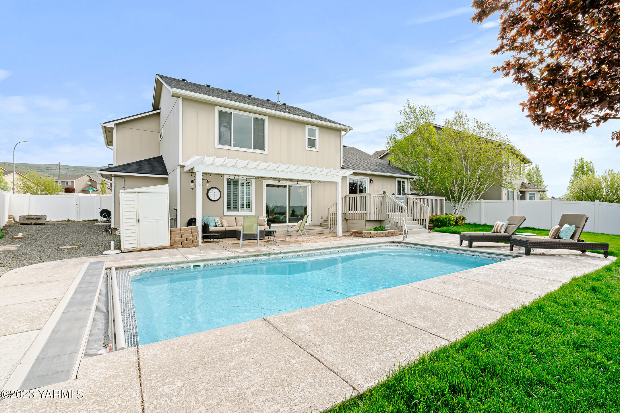 4702 Goat Rocks Court Yakima, WA 98901 - Photo 32 of 36 a view of a white house with a swimming pool and sitting area