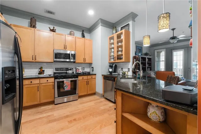 a kitchen with stainless steel appliances granite countertop a refrigerator and a sink