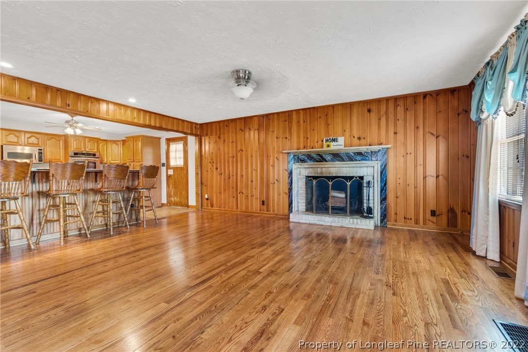 5457 Sambo Jackson Road Godwin, NC 28344 - Photo 12 of 33 an empty room with wooden floor and fireplace